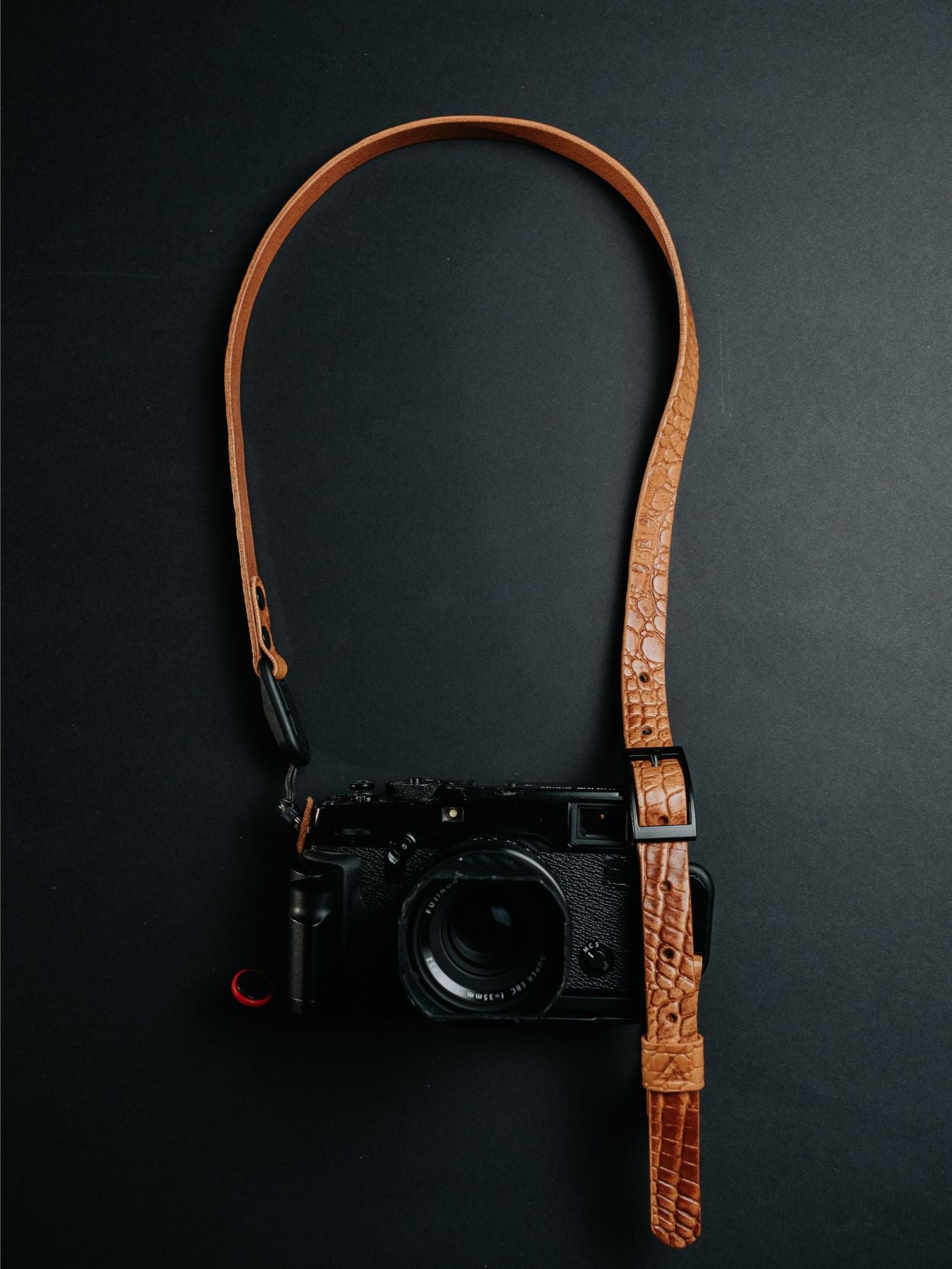 Lavietnamita adjustable camera strap embossed leather cognac colour with peak design anchor link and double snap rivets hanging on camera