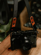 Lavietnamita handmade leather camera strap with two tone leather black and whiskey colours hanging on camera